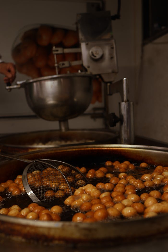 Delicious lokma dough balls being fried in Kütahya, Turkey. Sweet dessert preparation.