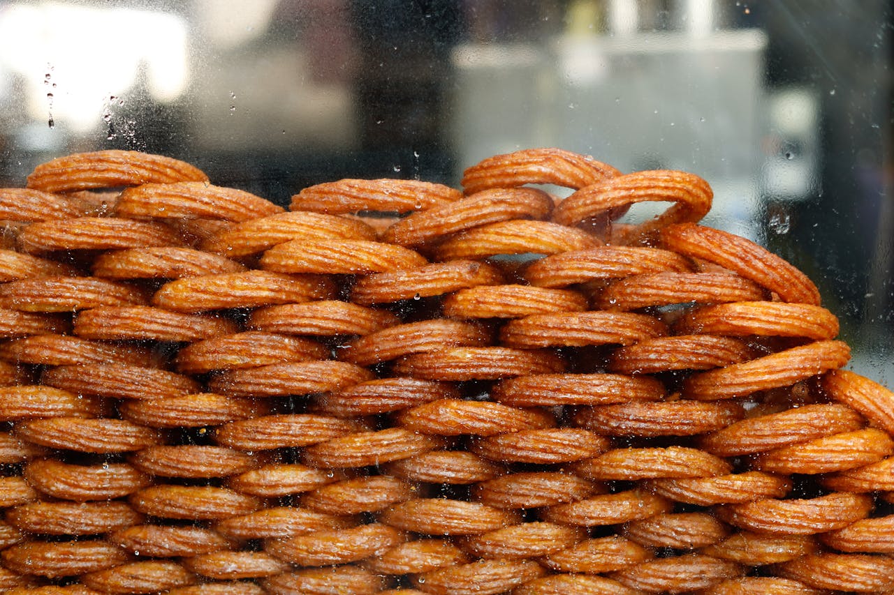 Detailed view of traditional Indian jalebi sweets stacked behind glass.